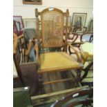 Late Victorian walnut rocking elbow chair with cane back and seat on turned supports