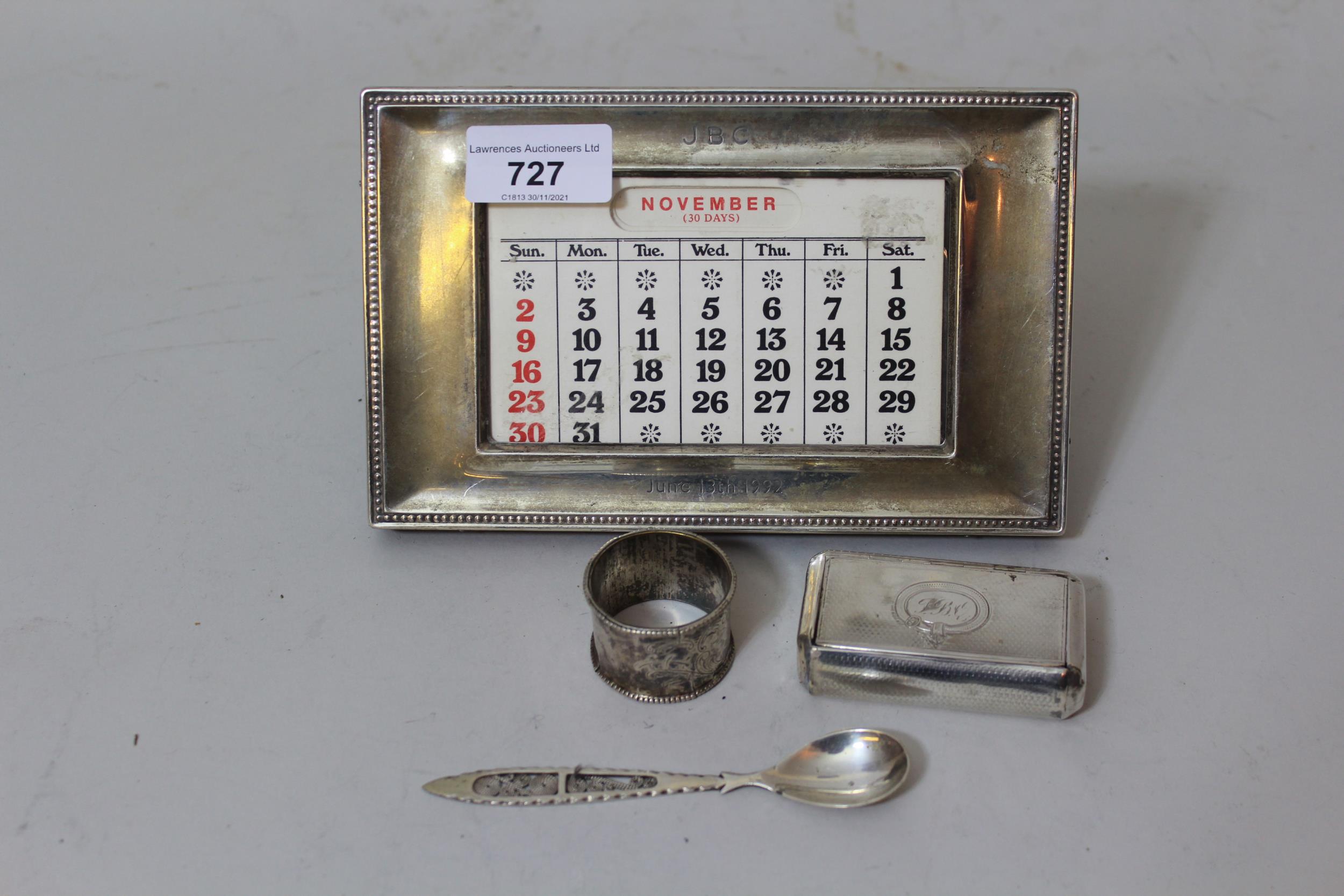 London silver mounted desk calendar, antique silver snuff box, a napkin ring and a spoon