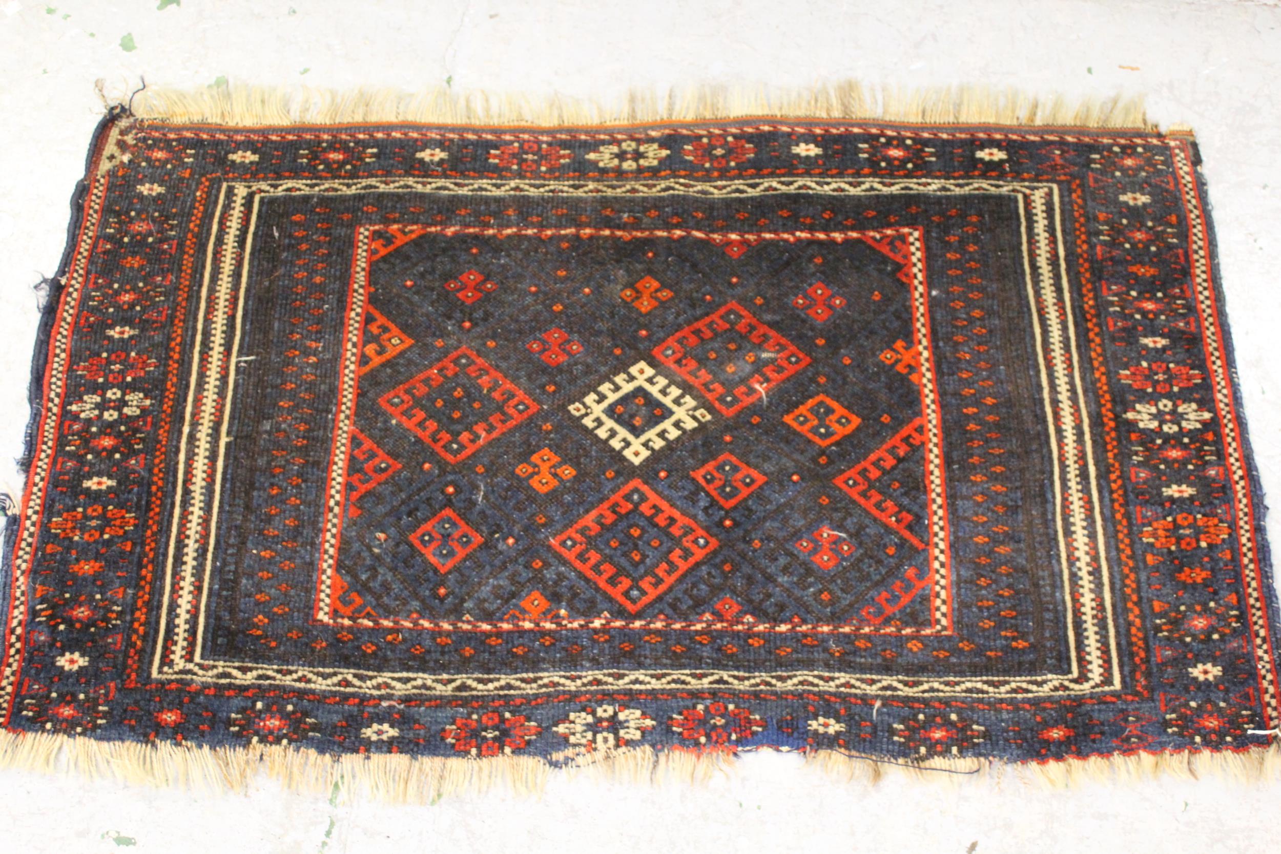 Small Belouch rug of geometric design with multiple borders, 24ins x 41ins together with another,