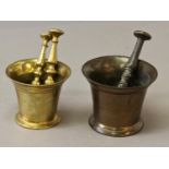 TWO SIMILAR BRONZE PESTLE AND MORTARS, both of traditional flared design, the smaller with ringed