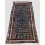 NORTH WEST PERSIAN KURDISH LONG RUG, circa 1910. The deep indigo field of stylised boteh