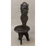 A CHINESE CARVED HARDWOOD STOOL, the raised back with a pierced hand hold above a shaped back