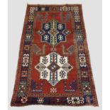 KAZAK RUG, Central Caucasus, circa 1900. The madder field with indigo and ivory stellar medallions