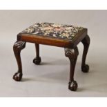 A GEORGE III STYLE MAHOGANY FRAMED STOOL, with rectangular drop in seat with needlework upholstery