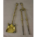 A PAIR OF 18TH CENTURY BRASS FIRE IRONS, the shovel with broad blade and 'button' decoration to