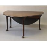 A GEORGE III MAHOGANY DROP FLAP DINING TABLE, the oval drop flap top on four turned tapering legs