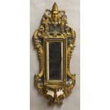 AN UNUSUAL GILTWOOD WALL MIRROR, with a central rectangular bevel edged plate with a lobed border