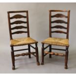 A PAIR OF LATE 18TH CENTURY RUSH SEATED LADDER BACK ARM CHAIRS, each with a dished top rail above