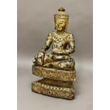 A DECORATIVE CARVED AND GILT THAI BUDDHA, the figure wearing a decorative headdress sitting cross