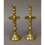 A PAIR OF MOROCCAN BRASS CANDLESTICKS, with broad sconces and baluster shaped columns with spreading
