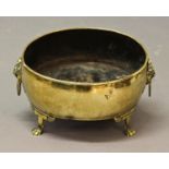 AN EARLY 19TH CENTURY BRASS JARDINERE, of oval shape with rolled rim, twin ring lion mask handles