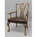 A GEORGE III STYLE CHIPPENDALE DESIGN ARM CHAIR, with a scrolling leaf carved top rail above a