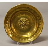 A 17TH CENTURY STYLE BRASS ALMS DISH, of circular dished form with a central raised rose within a