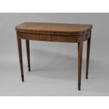 A GEORGE III MAHOGANY TEA TABLE, the folding top enclosing a polished tea surface with satinwood