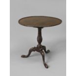 A GEORGE III STYLE MAHOGANY TRIPOD TABLE, with a circular tip-top with raised leaf carved border, on