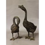 TWO BRONZE EFFECT SCULPTURAL GARDEN GEESE ORNAMENTS, one with head raised, the other lowered, 39