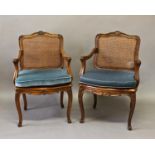 A PAIR OF LOUIS XVI STYLE ARMCHAIRS, with rectangular caned backs within moulded and leaf carved