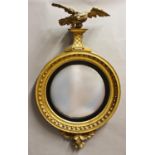 A REGENCY CONVEX GILT WOOD WALL MIRROR, the circular convex mirror plate in a broad moulded surround