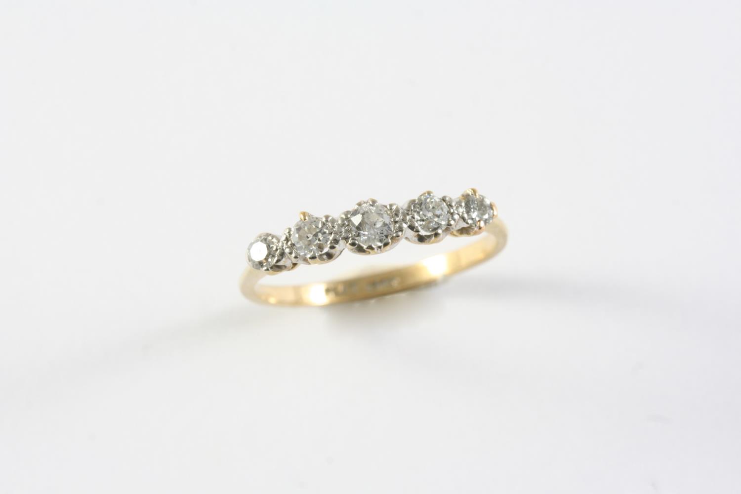 A DIAMOND FIVE STONE RING set with five graduated circular-cut diamonds, in 18ct gold. Size T 1/2