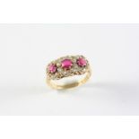 A RUBY AND DIAMOND TRIPLE CLUSTER RING the three circular-cut rubies are each set within a