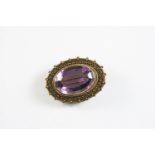 A VICTORIAN AMETHYST AND GOLD BROOCH the oval-shaped amethyst is set within a gold mount with ball