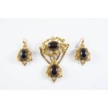 A VICTORIAN GARNET AND GOLD BROOCH the gold openwork foliate scrolling mount is set with two oval