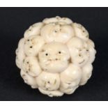 JAPANESE IVORY BALL - FACES a late 19thc or early 20thc Meiji period ivory ball, carved in the