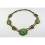 A CHINESE JADE NECKLACE formed with three oval-shaped pierced and foliate carved jade plaques and