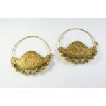 A PAIR OF EASTERN GOLD EARRINGS each with embossed Eastern inspired decoration, 9.5cm wide, 67