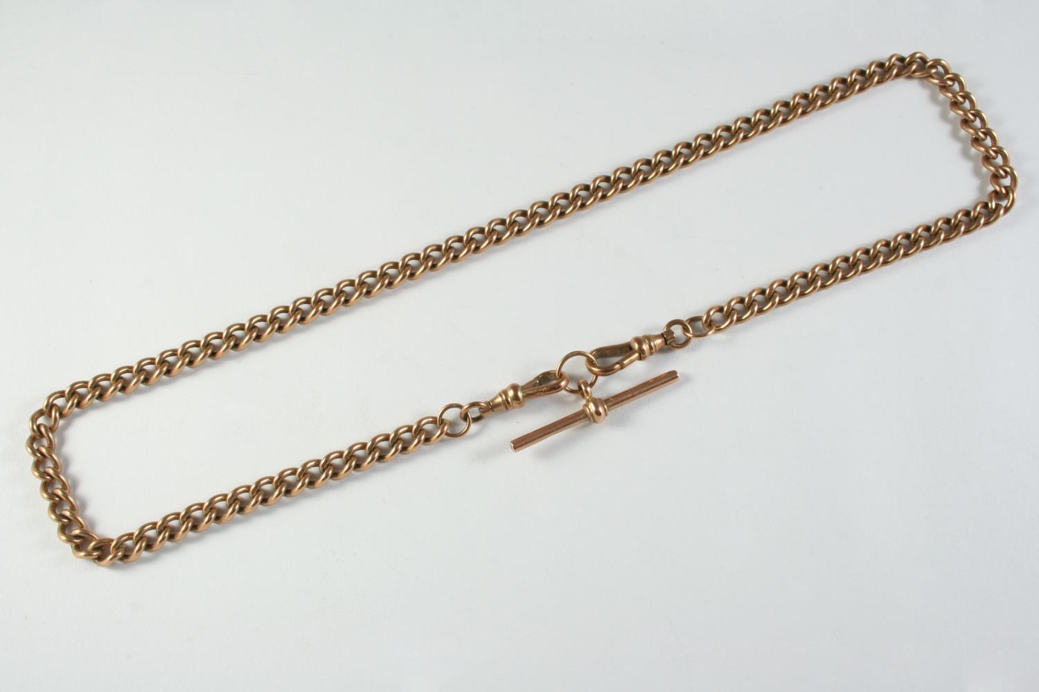 A 9CT GOLD CURB LINK WATCH CHAIN suspending a 9ct gold 't' bar, 45.5cm long, 39.6 grams