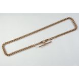 A 9CT GOLD CURB LINK WATCH CHAIN suspending a 9ct gold 't' bar, 45.5cm long, 39.6 grams