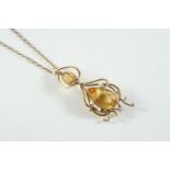 A GOLD, CITRINE AND CULTURED PEARL PENDANT the gold openwork scrolling mount set with an oval-shaped