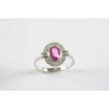 A PINK SAPPHIRE AND DIAMOND CLUSTER RING the oval-shaped pink sapphire is set within a surround of