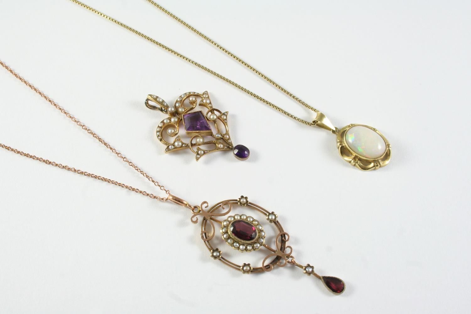 AN EDWARDIAN AMETHYST AND PEARL SET PENDANT the gold openwork mount is centred with a kite-shaped