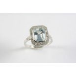 AN AQUAMARINE AND DIAMOND CLUSTER RING the step-cut aquamarine is set within a surround of two