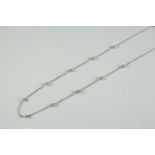 A DIAMOND AND GOLD CHAIN NECKLET the 18ct white gold chain is mounted with ten roundells each set