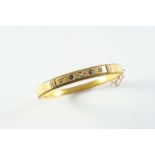 A GOLD, SAPPHIRE AND DIAMOND HALF HINGED BANGLE the 15ct gold bangle is set to one side with three