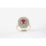A RUBY AND DIAMOND CLUSTER RING the oval-shaped ruby is set within a double surround of circular-cut
