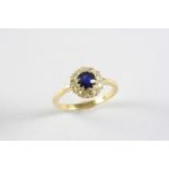 A SAPPHIRE AND DIAMOND CLUSTER RING the circular-cut sapphire is set within a surround of circular-