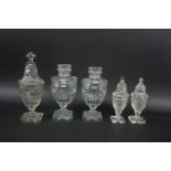 PAIR OF 19THC GLASS LIDDED URNS the lids with a star shape motif to the flat tops, with faceted