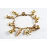 A GOLD CURB LINK CHARM BRACELET with padlock clasp and mounted with assorted gold charms, total