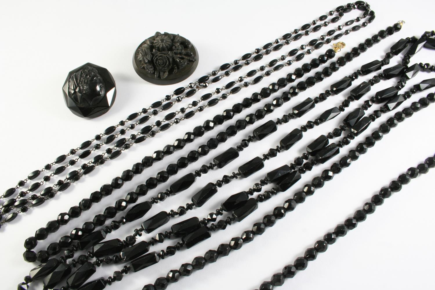 ASSORTED JET NECKLACES and two carved brooches