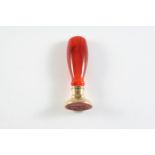 A 19TH CENTURY CARNELIAN AND GOLD DESK SEAL the waisted carnelain seal with plain gold base, the