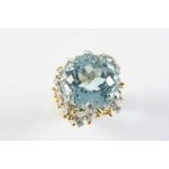 AN AQUAMARINE AND DIAMOND RING the circular-cut aquamarine set within a two colour gold openwork