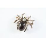 A VICTORIAN GARNET AND DIAMOND SPIDER BROOCH the body set with an oval cabochon garnet, with rose-