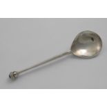 A CONTEMPORARY HANDMADE SPOON with a hammered finish and a knop finial, set with a dark red