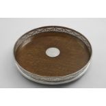 A VICTORIAN CIRCULAR MOUNTED OAK GALLERY TRAY on three bun feet, the centre with a circular