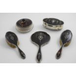 AN EARLY 20TH CENTURY MOUNTED TORTOISESHELL PART TOILET SET TO INCLUDE:- a lobed oval jewel box, a