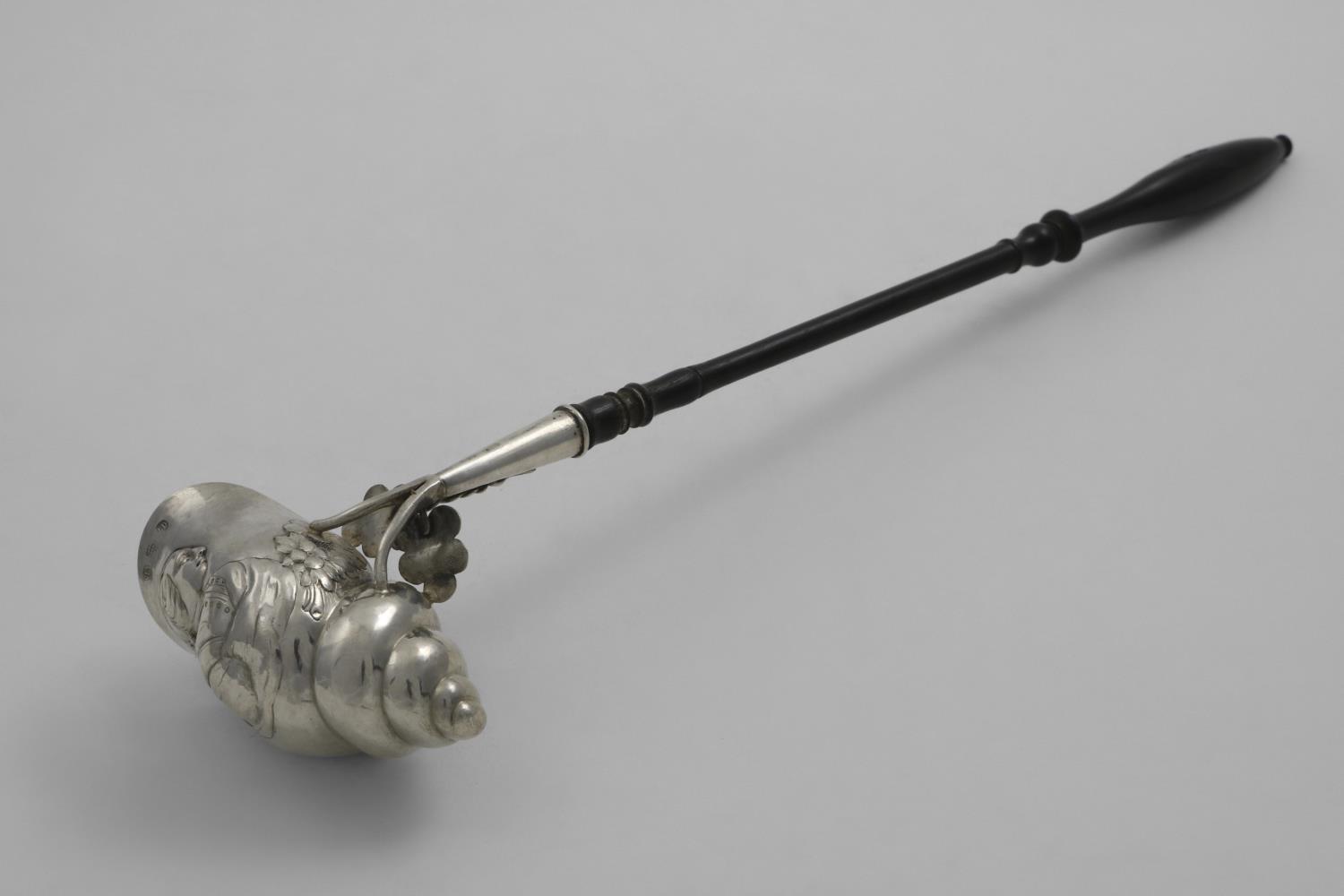 AN EARLY 19TH CENTURY NORWEGIAN PUNCH LADLE with an ebonised, turned wooden handle and an embossed