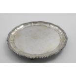 A MID 20TH CENTURY INDIAN SALVER of shaped circular outline with a gadrooned border and four paw